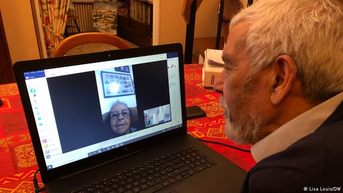 Emile Hoarau in front of a computer speaking via video chat to his sister Marie Thérèse Paye, seen on the screen