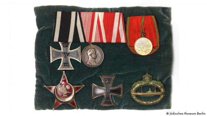 Ein Samtkissen mit sechs Medaillen, darunter die österreichische Medaille mit dem Abbild von Karl I., der Eiserne Halbmond, zwei Ausfertigungen des Eisernen Kreuzes und das U-Boot-Kriegsabzeichen.