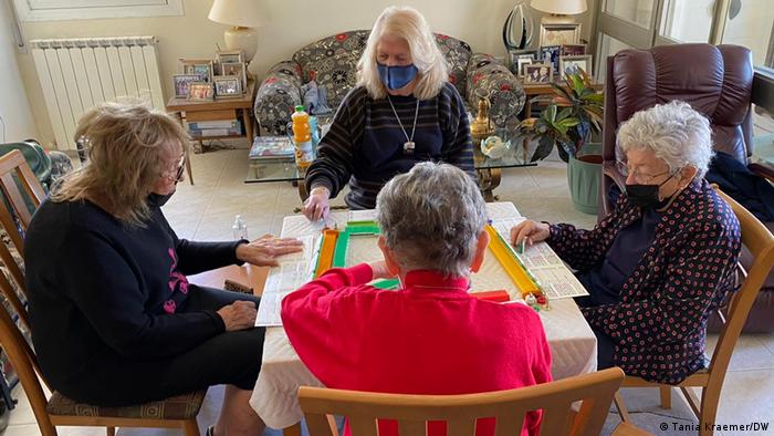 A group of women sitting around a table playing Mahjong