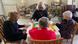 A group of women sitting around a table playing Mahjong A group of women sitting around a table playing Mahjong
