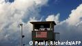 (FILES)In this photo reviewed by US military officials, a member of the US military mans one of the guard posts at sunrise at Camp Delta, part of the US Detention Center in Guantanamo Bay, Cuba, on March 30, 2010. - US President Joe Biden wants to close the Guantanamo Bay prison for terror suspects before the end of his term, the White House said February 12,2021, echoing an unfulfilled campaign promise from Barack Obama's administration. Asked at a press conference about a possible closure of the prison in Cuba during Biden's tenure, spokeswoman Jen Psaki said, That certainly is our goal and our intention. (Photo by Paul J. RICHARDS / AFP)