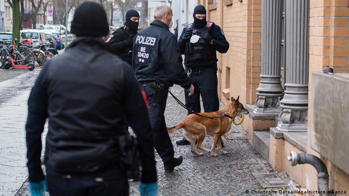 police take a sniffer dog in to search a house in Berlin