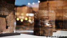 Sammlung Benin, Rautenstrauch-Joest-Museum Teil des It’s Yours-Raumes von Peju Layiwola Foto: © Francis Oghuma Kult-Objekte als koloninale Trophäen
Die nigerianische Künstlerin Peju Layiwola hat einen von vier „It´s Yours“-Räumen gestaltet. Objekte aus Benin (dem heutigen Nigeria) zeugen darin von geraubten Kulturgütern. Das RJM besitzt 95 Benin-Bronzen. Sie wurden vom Sammler Rautenstrauch in London erworben - wenige Jahre nachdem die Briten 1897 einen antikolonialen Aufstand blutig niedergeschlagen hatten und die Bronzen als Trophäen mitgenommen hatten.
