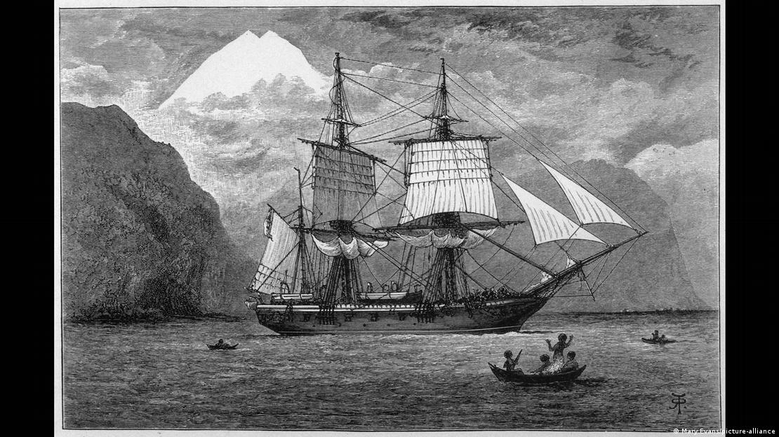 Pintura do HMS Beagle em navegaão, com pessoas em pequena canoa ao lado e montanhas ao fundo