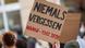 Женщина держит плакат с надписью "Никогда не забывать" и датой теракта в Ханау Женщина держит плакат с надписью "Никогда не забывать" и датой теракта в Ханау