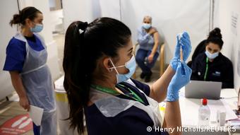 Женщина готовится к прививке от коронавируса, Лондон