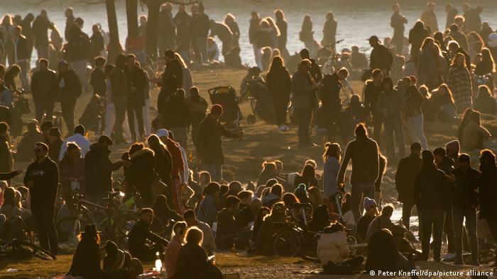 Centenas de pessoas reunidas às margens do rio Isar, que corta a cidade de Munique