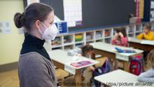 Eine Lehrerin mit FFP2-Maske unterrichtet in einer ersten Klasse an einer Grundschule mit Wechselunterricht. Nach einem zweimonatigen Lockdown haben ab dem 22. Februar in mehreren Bundesländern wieder Schulen und Kitas unter bestimmten Hygienekonzepten geöffnet. So findet an Schulen zum Beispiel Wechselunterricht statt.