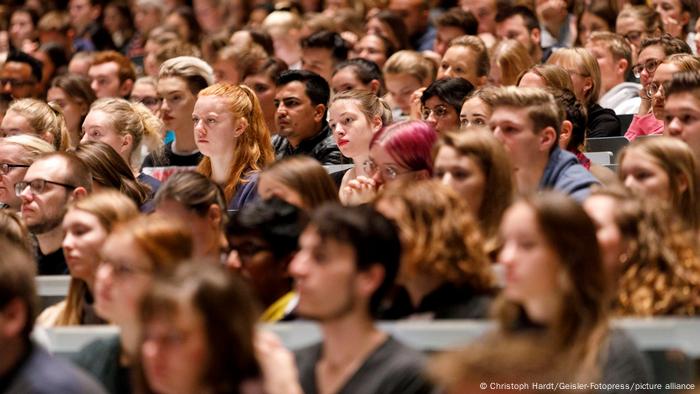 Blick auf eine große Zahl junger Menschen, die in einem Saal sitzen und nach vorne schauen