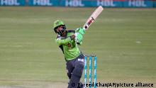 Lahore Qalandars Mohammad Hafeez follows the ball after playing a shot for six during a Pakistan Super League T20 cricket match between Lahore Qalandars and Quetta Gladiators at the National Stadium, in Karachi, Pakistan, Monday, Feb. 22, 2021. (AP Photo/Fareed Khan)