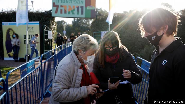 Israel I Frauen zeigen Impfpass in Tel Aviv park