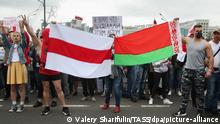 MINSK, BELARUS - AUGUST 23, 2020: People hold the former and the actual flags of Belarus during an opposition rally by the Minsk Hero City Obelisk. The political crisis that arose amid the announcement of the 2020 Belarusian presidential election results on August 9, continues in Belarus; mass protests against the election results have been hitting major cities across Belarus resulting in violent clashes with the police. Valery Sharifulin/TASS