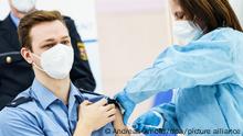 A German police officer receives his coronavirus vaccine