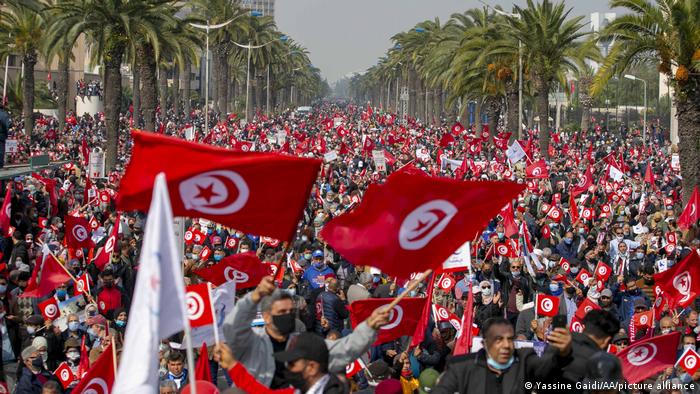 Protesters gather in the Tunisian capital Tunis waving national flags