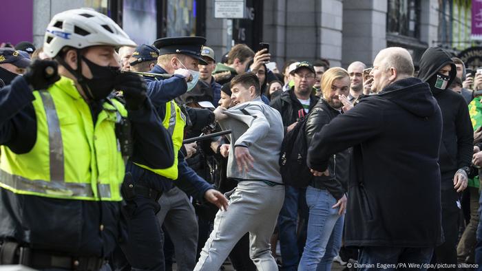 Eine aufgebrachte Menge gerät bei Protesten in Dublin gegen die Corona-Maßnahmen | mit Polizeikräften zusammen Eine aufgebrachte Menge gerät bei Protesten in Dublin gegen die Corona-Maßnahmen | mit Polizeikräften zusammen