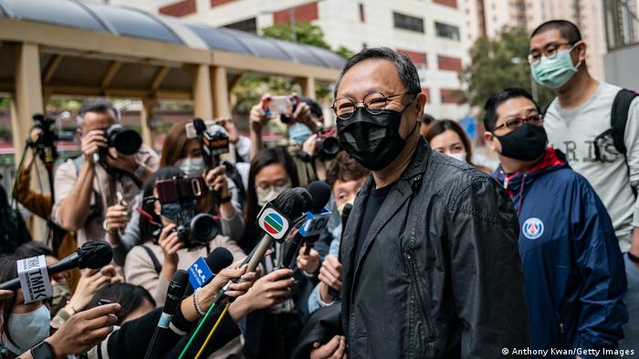 El activista prodemocracia Benny Tai es recibido por los medios cuando se presenta en la estación de policía luego de ser acusado (28.02.2021)