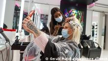 Als erster Kundin des Friseurladens Magali Coiffeur werden Arielle Rippegather nach der Wiedereröffnung die Haare geschnitten und gefärbt. Nach wochenlanger Zwangspause wegen der Corona-Pandemie sind bereits in der Nacht die ersten Friseure wieder ihrer Arbeit nachgegangen.