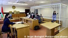 Belarusian journalist Katsiaryna Barysevich, right, and Dr. Artom Sorokin, seen left in cage, attend a court hearing in Minsk, Belarus, Tuesday, March 2, 2021. On Tuesday, the Moskovsky District Court in Minsk sentenced Barysevich to six months in prison and a fine equivalent to $1,100. It also handed a two-year suspended sentence to Artsyom Sarokin, a doctor who treated protester and shared his medical records with Barysevich, and fined him the equivalent of $550. (Sergei Sheleg/BelTA Pool Photo via AP)