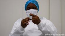 A health professional prepares the dose of the Oxford/AstraZeneca vaccine at the Central Vaccine depot in Luanda on March 2, 2021. (Photo by Osvaldo Silva / AFP)