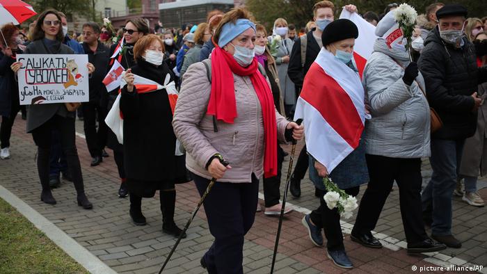 People, most of them pensioners, hold old Belarusian national flags march during an opposition rally to protest the official presidential election results in Minsk, Belarus, Monday, Oct. 26, 2020