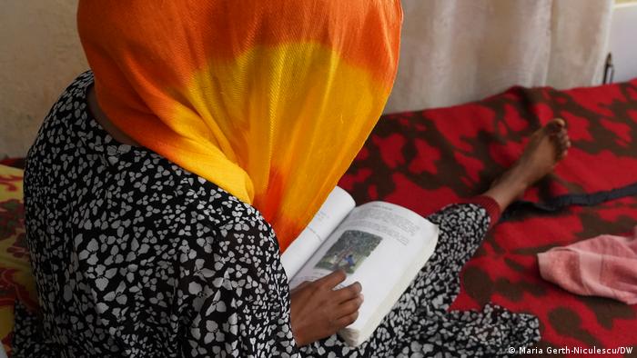 A Tigray rape survivor in a safe house reading. 