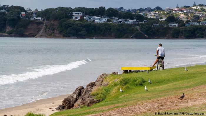 A man looks out onto a beach following a tsunami warning in Orewa, north of Auckland