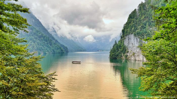 An electric boat crossing Lake Königsee in the Alps at Berchtesgaden, Germany An electric boat crossing Lake Königsee in the Alps at Berchtesgaden, Germany