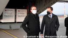Slovak Prime Minister Igor Matovic, right, and Health Minister Marek Krajci at Kosice Airport, Slovakia, Monday March 1, 2021, as Russia's Sputnik V coronavirus vaccine arrives. Hard-hit Slovakia signed a deal to acquire 2 million dozes of Russia’s Sputnik V coronavirus vaccine. The country's prime minister says Slovakia will get one million shots in next two months while another million will arrive in May and June. (Frantisek Ivan/TASR via AP)