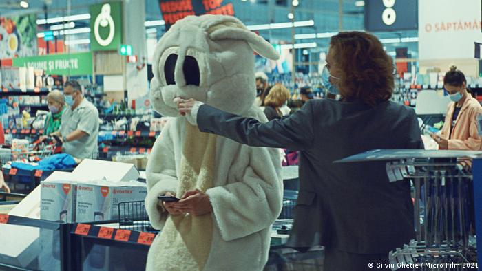 A still from 'Bad Luck Banging or Loony Porn': A masked person touching the nose of a person dressed as a rabbit
