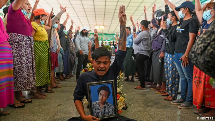 En este funeral en Rangún, los manifestantes levantan la mano en un gesto simbólico de batalla.