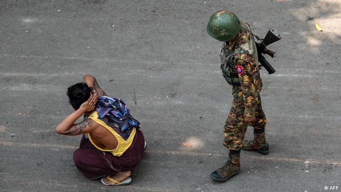 Un soldado vigila a un hombre en las calles de Mandalay.