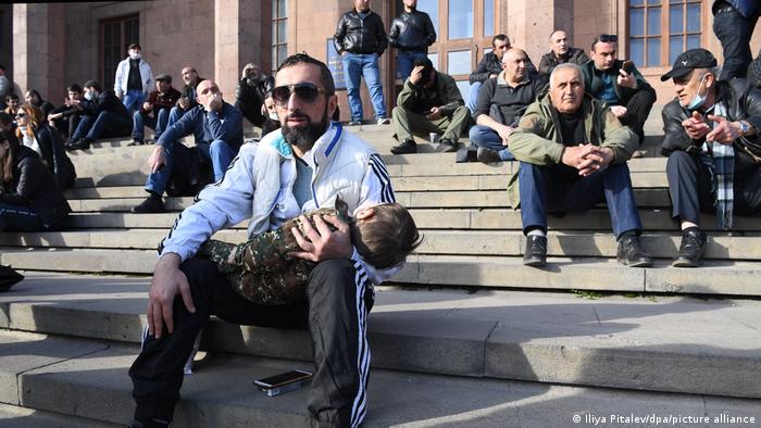 Protestors sit on stairs during a rally in support of Armenia's general chief of staff