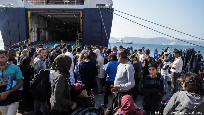 Migrants gather near a large ferry on the Greek mainland