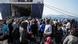 Migrants gather near a large ferry on the Greek mainland Migrants gather near a large ferry on the Greek mainland