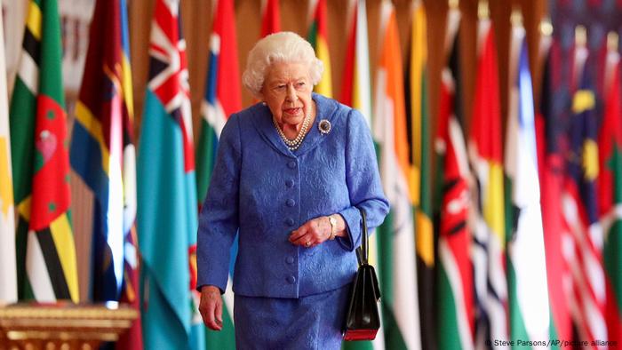 Queen Elizabeth walks past Commonwealth flags at Windsor Castle, England