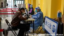 (210123) -- BEIJING, Jan. 23, 2021 (Xinhua) -- A resident registers for injection of the second dose of the COVID-19 vaccine at a sports center in Daxing District, Beijing, capital of China, Jan. 23, 2021. Beijing has completed administering the first dose of the jab among specific groups of people with higher infection risks by Jan. 19, and over 1.9 million people in Beijing have received the first dose of COVID-19 vaccine. Starting from Jan. 22, COVID-19 vaccine recipients in Beijing who have received the initial dose will be given the second dose to maximize the effect of the vaccine, an inactivated one. According to work plans, injection of the second vaccine shot among specific groups of people will be completed by Feb. 8. (Xinhua/Peng Ziyang)