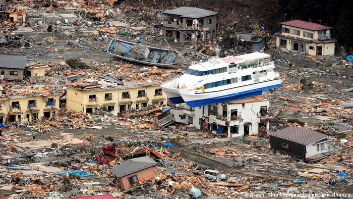 Blick auf die völlig zerstört japanische Kleinstadt Ōtsuchi: Ein Schiff liegt auf dem Dach eines Hauses, alles drumherum liegt in Trümmern - nach Erd-/ Seebeben 2011 in Japan