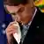 Brazilian President Jair Bolsonaro removes his mask worn due to the COVID-19 pandemic to address a ceremony to sign a law that expands the federal government's ability to acquire vaccines