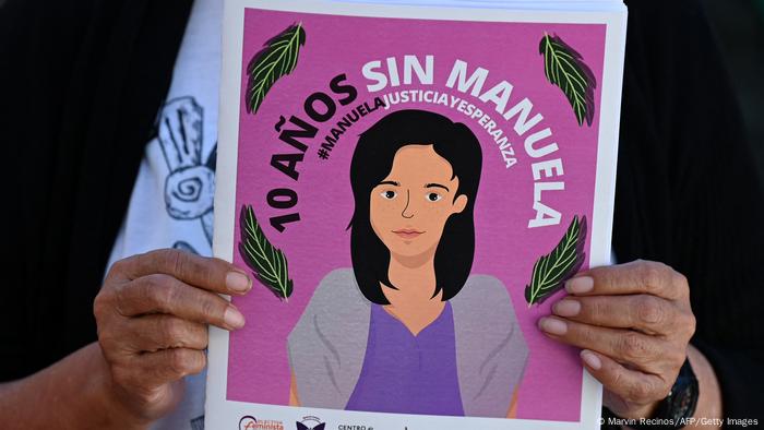 Foto de una persona que sostiene un rótulo con un dibujo de Manuela en una imagen de archivo