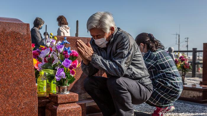 people pray at graves in Japan