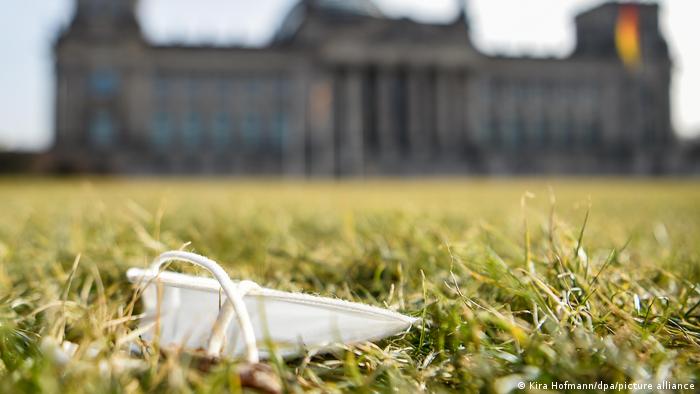 Mascarilla contra el coronavirus, tirada sobre un parque frente al Bundestag, en Berlín.