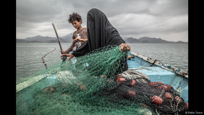 Una mujer pesca junto a su hijo en Yemen.