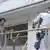 Handwerker ziehen Klebeband an frisch gestrichenem Gebäude ab