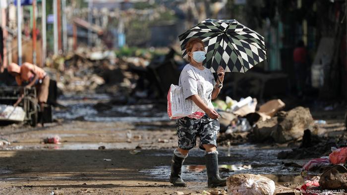 A woman walking down a road in Nangka, Philippines, after it was hit by a typhoon