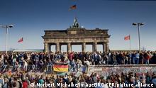 Fall der Berliner Mauer: Menschen aus Ost- und West-Berlin sind auf die Mauer am Brandenburger Tor geklettert, Berlin, Deutschland, Europa