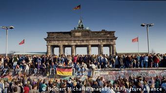 Fall of the Berlin Wall: People from East and West Berlin climbed the wall at the Brandenburg Gate, Berlin, Germany