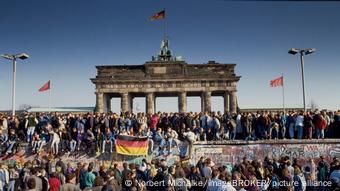 Fall of the Berlin Wall: People from East and West Berlin climbed the wall at the Brandenburg Gate, Berlin, Germany