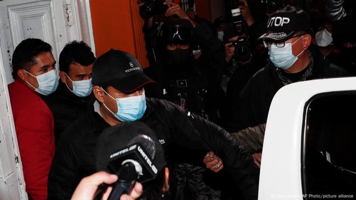 El exministro de Justicia, Álvaro Coímbra (en el centro) y el exministro de Energía, Rodrigo Guzmán (de negro y detrás de Coimbra) son escortados por la policía en La Paz (12.03.2021)