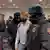 Двое полицейских уводят из зала участника форума "Муниципальная Россия"