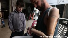 ***ACHTUNG: Bild nur im Zumsammenhang mit der BG Photos and testimonies from Syrian photographers und nur bis zum 15.4.2021 verwenden!***
via Friedel Taube
Douma, 2014. Mohammad, 8 years old, looks at his father's prosthesis as he tries on an artificial arm.
©Bassam Khabieh